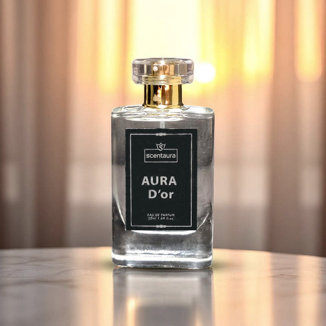 Perfume bottle labeled 'Aura D'or' on a reflective surface with a blurred background