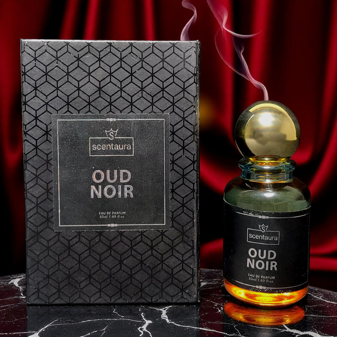 Oud Noir perfume bottle and packaging on a dark surface with red curtain background